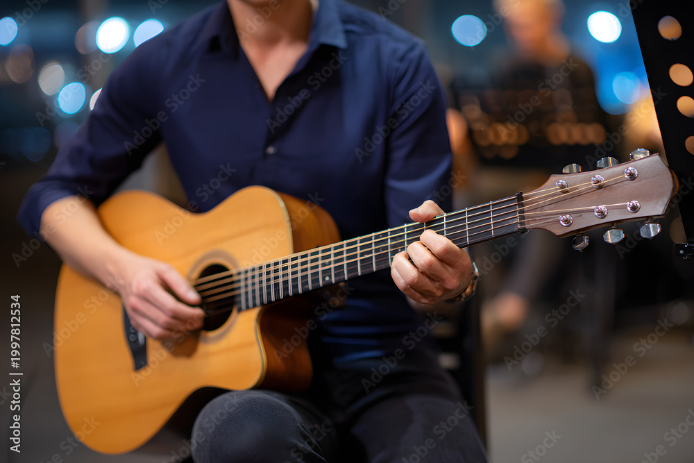 Obraz premium Man Playing Acoustic Guitar During A Live Performance With Out Of Focus Background Lights