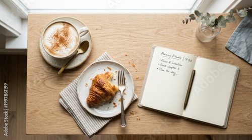 Cozy morning ritual with coffee, croissant, and journal on a wooden table