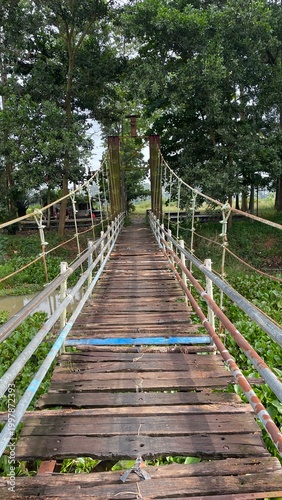 Rustic Suspension Bridge Over Water with Wooden Structure and Scenic Natural Landscape View