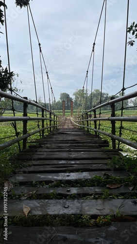 Rustic Suspension Bridge Over Water with Wooden Structure and Scenic Natural Landscape View