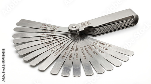 A fanned-out collection of metal feeler gauges, displaying different blade thicknesses in millimeters and inches, essential for precise gap measurements in automotive and engineering tasks
