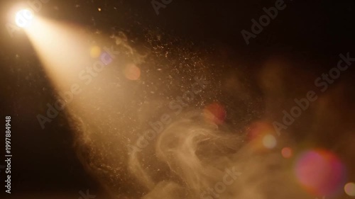 Dramatic golden light beam through dust and smoke in darkness