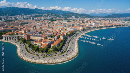 Aerial view of curved seaside city boulevard with marina, terracotta roofs and mountains