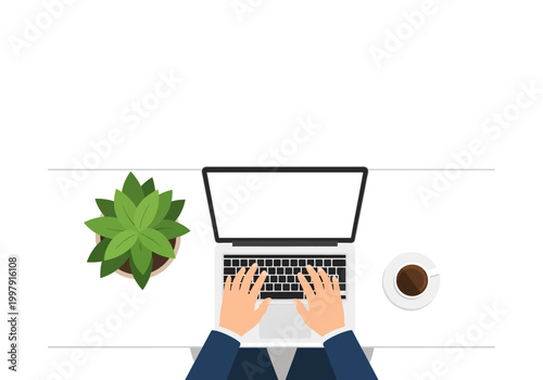 Overhead view of hands typing on a laptop beside a plant and coffee