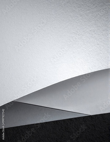 a white and black textured wall softly illuminated by warm ambient light, creating gentle shadows and a calm, minimalist atmosphere