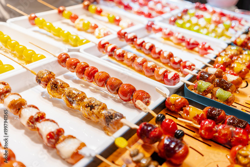 Traditional Chinese candied fruit snacks, known as Tanghulu at street food market.