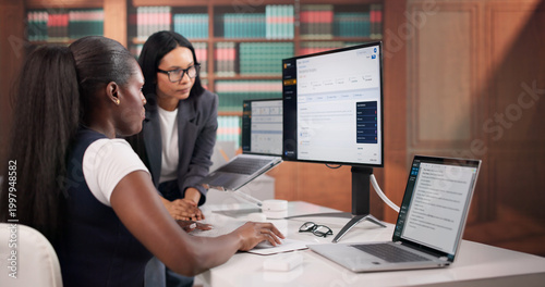 Lawyer Carefully Reviewing Contract Documents On Laptop