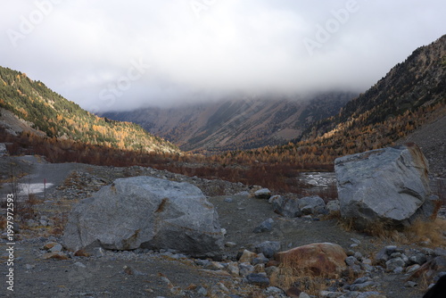 Cuadro en lienzo Misty mountains loom above a rugged, rocky valley