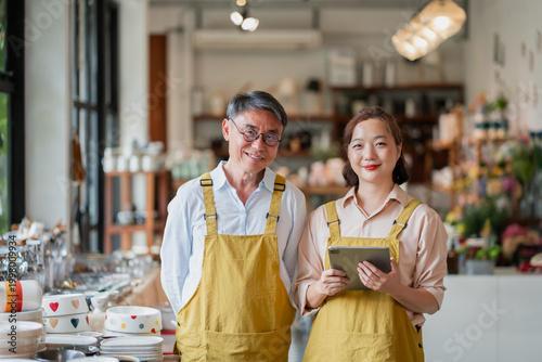 Quadro su tela Father and daughter Asian small business owners standing in their shop