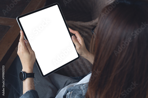 Mockup blank screen digital tablet,  woman  using tablet with empty screen for online marketing or mobile app design, closeup