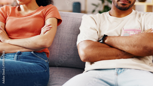 Photos Crossed arms, couple and conflict in home, anger or tension with marriage problem on couch