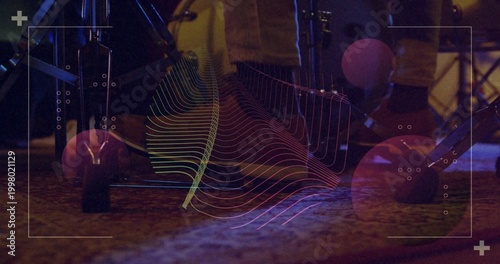 Glowing drum kit showing rubber-capped spurs, pedal axle and cables on carpeted stage with overlay