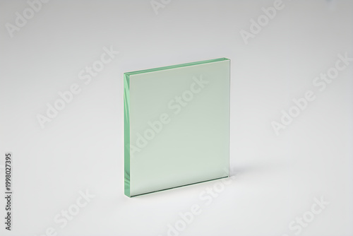 Square piece of transparent green tinted glass on white background