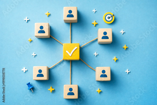 Wooden blocks with icons connect to a central cube featuring a check mark to illustrate organizational harmony and successful teamwork strategies within a professional.