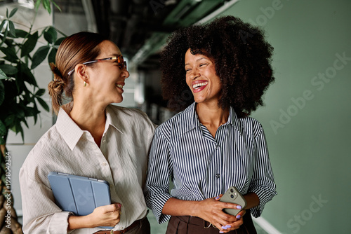 Obraz na plátne Portrait of two young business woman having a meeting or presentation and seminar standing in the office