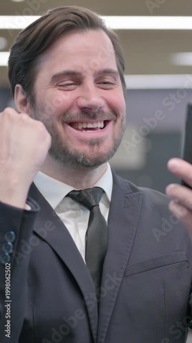 Portrait of Businessman Celebrating on Smartphone, Vertical Video