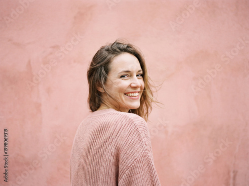 Portrait in Pink Sweater by Textured Wall