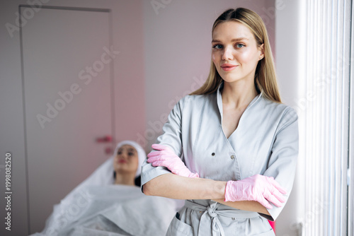Foto Medical aesthetician with crossed arms wearing gloves in a beauty clinic, client