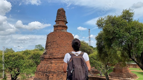 Foto Woman exploring historic ayutthaya ruins, admiring ancient pagodas and stupas, e