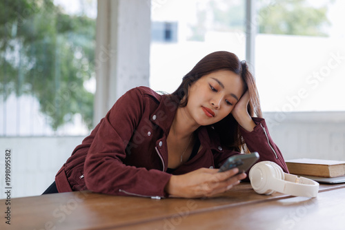 Young woman using smartphone feeling bored or tired