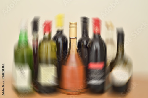 Set of bottles of different alcoholic beverages. Concept of alcoholism and alcohol addiction as a social problem. Spin blur effect applied.