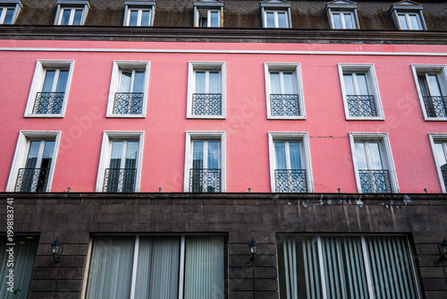 Urban building with pink wall and dark stone base