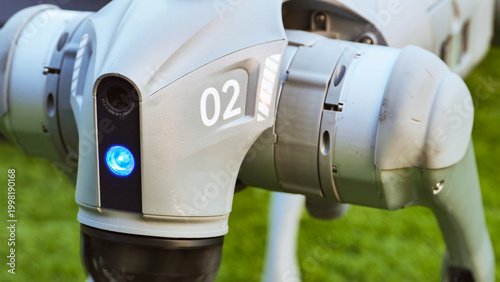 Robotic dog head with camera and blue light on green background
