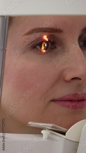 Female ophthalmologist examining patient eye with medical equipment