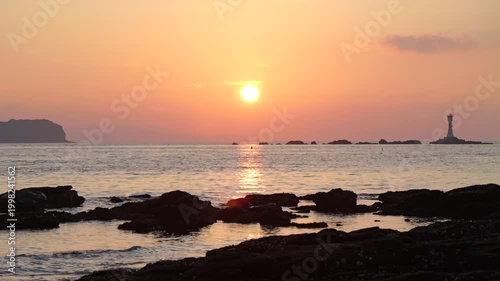 少しピンク色になってきた夕焼けの空と海