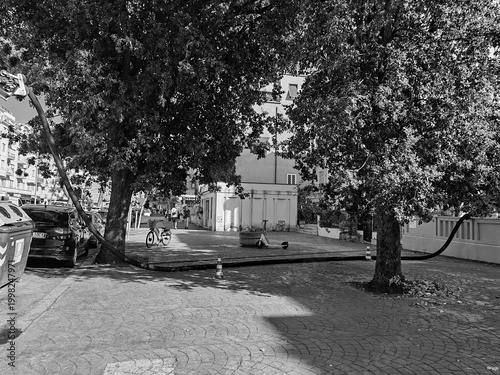 Rome, Italy - June 16, 2025, water pumping tanker with hose running across a sidewalk, for suction.