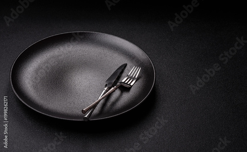 Obraz na plátne An empty ceramic round plate, kitchen utensils for a dinner table