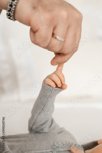a newborn baby's hand in its parents' hands in close-up