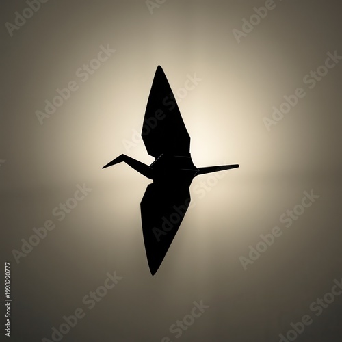 Silhouette of origami crane bird against a soft glowing light background