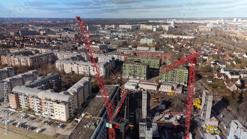Fotografie Aerial view of urban construction site with cranes and residential buildings in