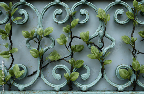 Detail of decorative fence panel with climbing green plants.