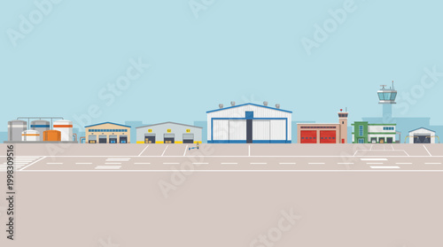 Airfield buildings stand on tarmac under clear sky with control tower