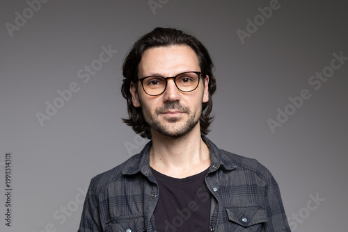 Tableau sur toile Smart professional man in glasses and plaid shirt with slight smile