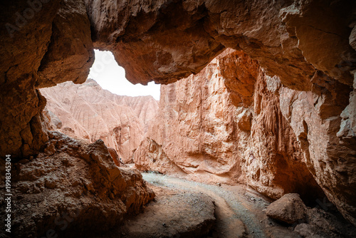Quadro em tela Cave entrance scenery in Huoyun Valley Canyon, unique Danxia landform cliffs and