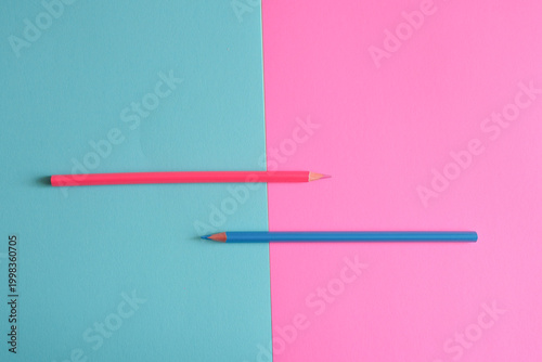 Obraz na płótnie Two colored pencils on divided pink and blue background