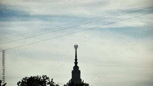 Man silhouetted ziplining across Moscow sky with Moscow State University spire