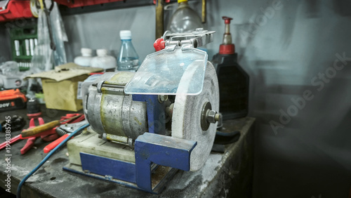 bench grinder machine with a protective shield, used for polishing and sharpening tools. Perfect for industrial or workshop settings.