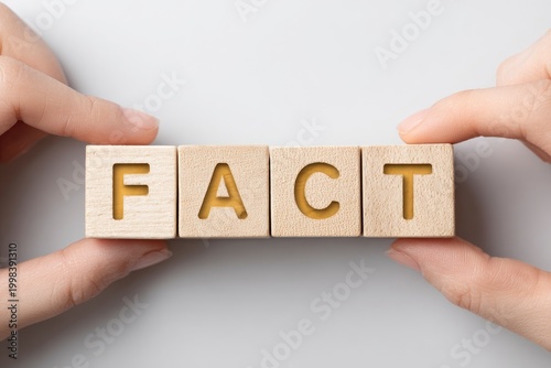Hands holding wooden blocks with fact.