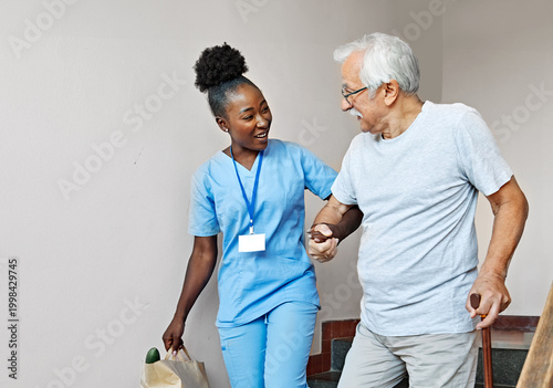 Εκτύπωση καμβά Doctor or nurse caregiver helping disabled senior man walking down the stairs at