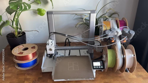 Barnaul, Russia, 15 March 2026 ? Bambu Lab A1 3D printer with AMS multi-color filament system on wooden desk surrounded by colorful PLA spools.