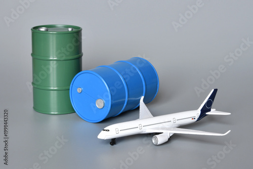 Miniature oil barrels with an airplane. Concept of rising fuel prices and the associated economic impact on aviation due to the Middle East crisis and the war in Iran.