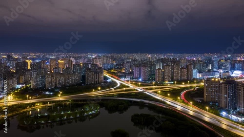 Skyscrapers glow with warm office lights as traffic forms long streaks of red and white along the streets below