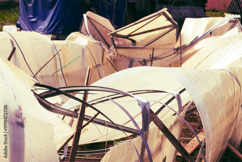 Foto Greenhouse structure in disrepair with broken panels and scattered materials nea