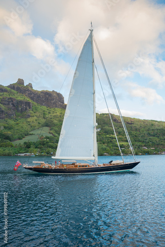 Foto Classic Sailing Superyacht with mainsail hoisted leaving Cook's Bay, in the paci