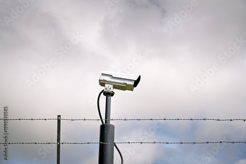 Εκτύπωση καμβά Surveillance CCTV Camera Mounted Above Barbed Wire Fence