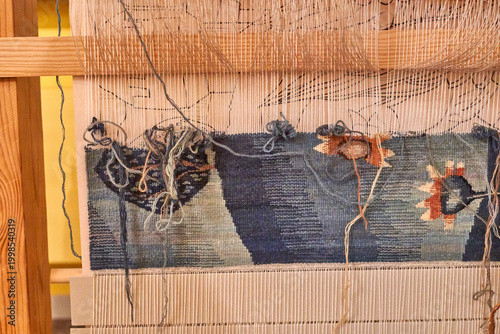 Foto A close-up view of a wooden weaving loom with a partially completed tapestry in progress
